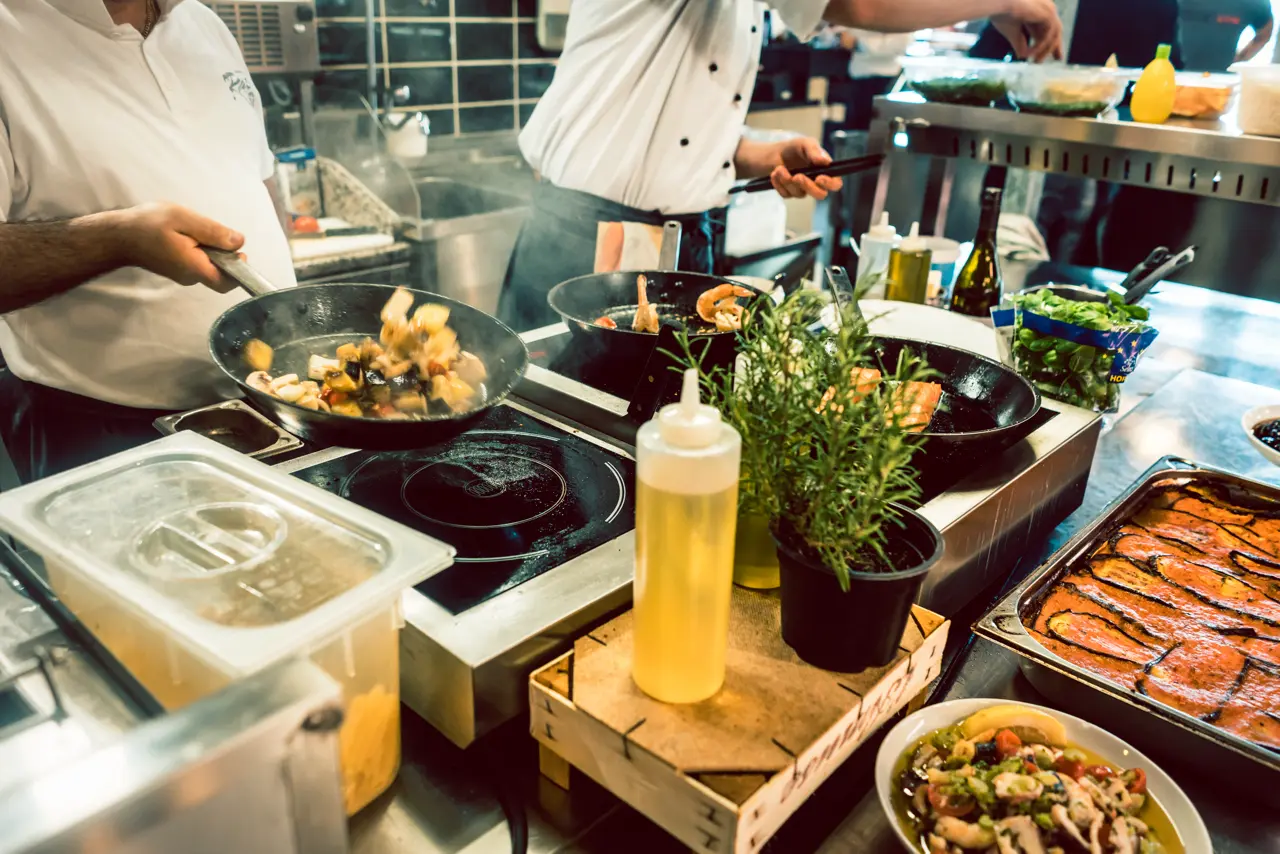Kuchnia z gotującymi kucharzami przygotowują catering dietetyczny